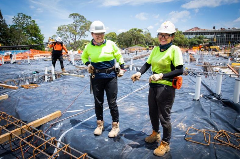Two women working on a construction site in high viz safety gear