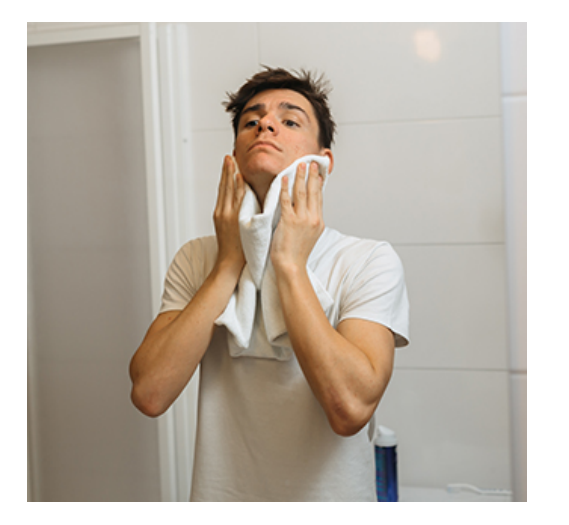 man drying face with towel
