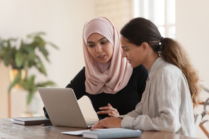 2 women collaborating in front of a laptop