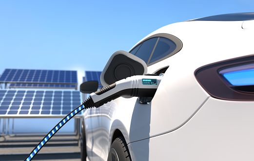 electric car with plug recharging - with solar panels in background