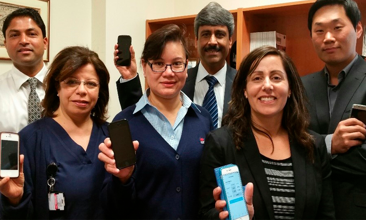 Group of 3 men and 3 women holding up mobile phones