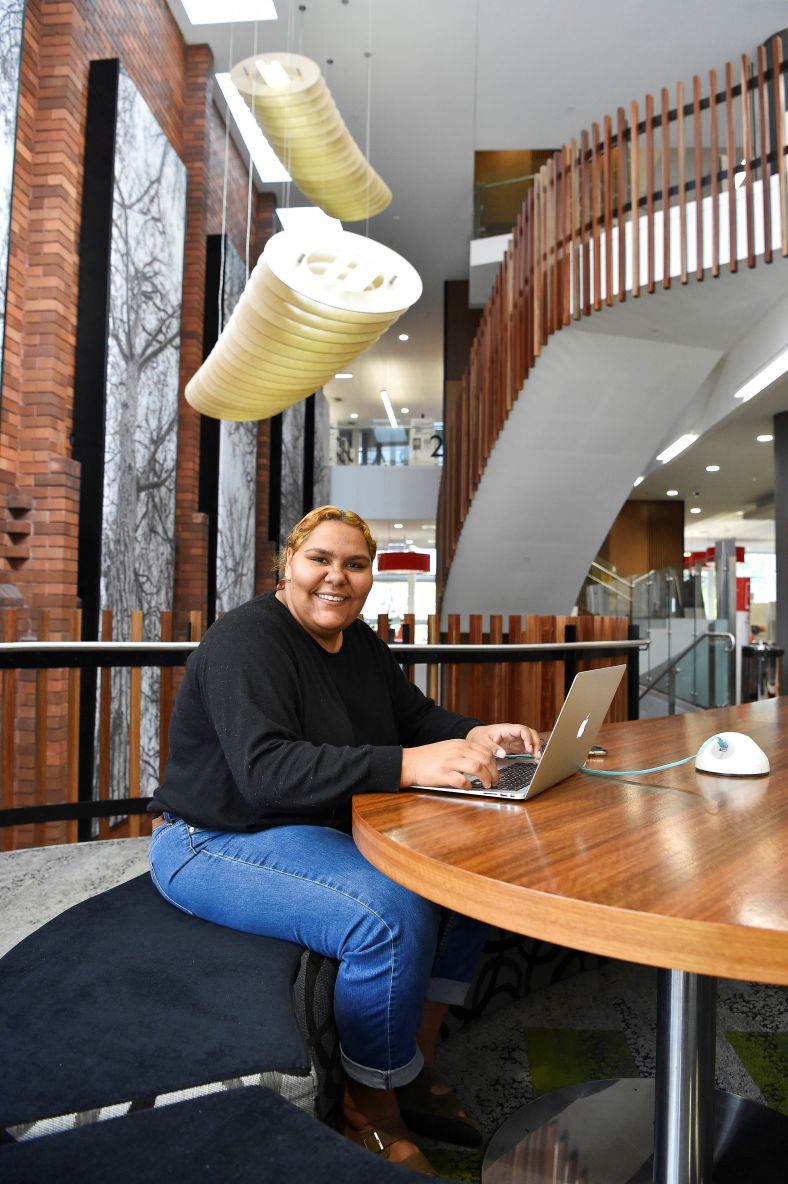 Aboriginal and Torres Strait Islander woman at computer in library