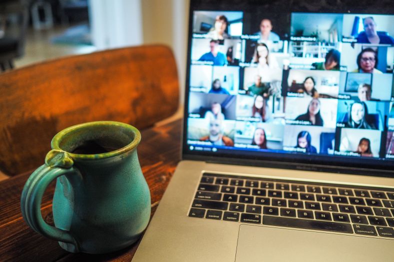 Laptop displaying an online meeting on screen,