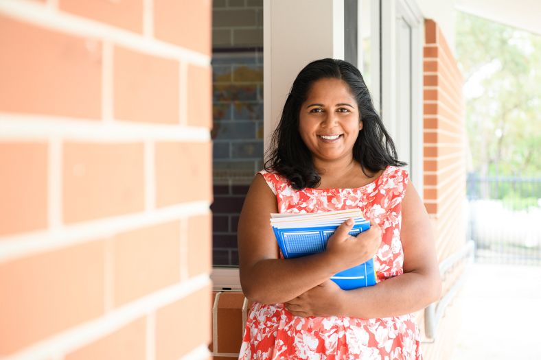 Female teacher in regional Australia at a school holding books