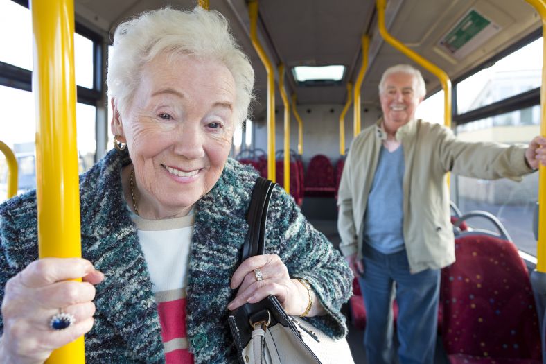 Two seniors travelling on a bus