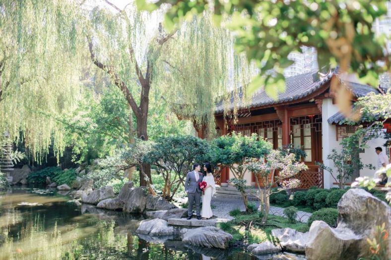 Couple by a tree next to the pond at the Chinese Friendship Garden
