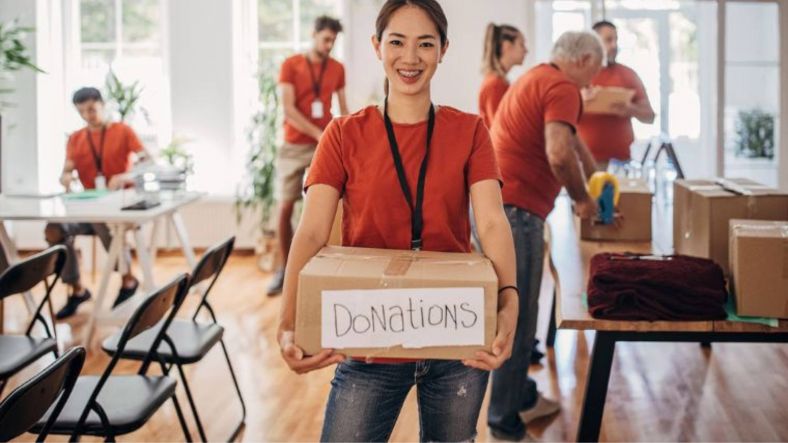 Girl in red t-shirt holds a donations box