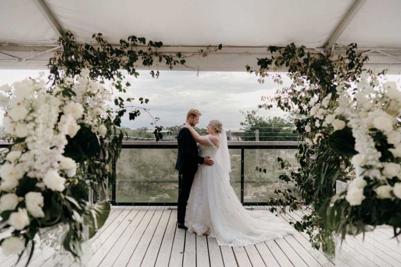 A couple getting married at Sydney Zoo in a space styled with flowers