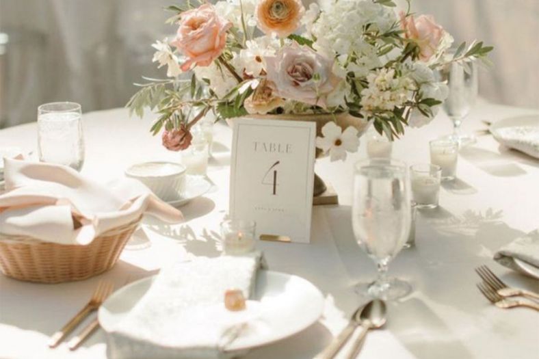 A table setting with crockery, glassware and flowers