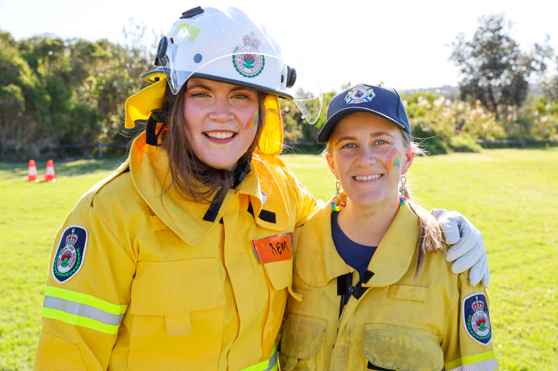two girls on fire volunteers smiling at the camera in their rescue uniforms