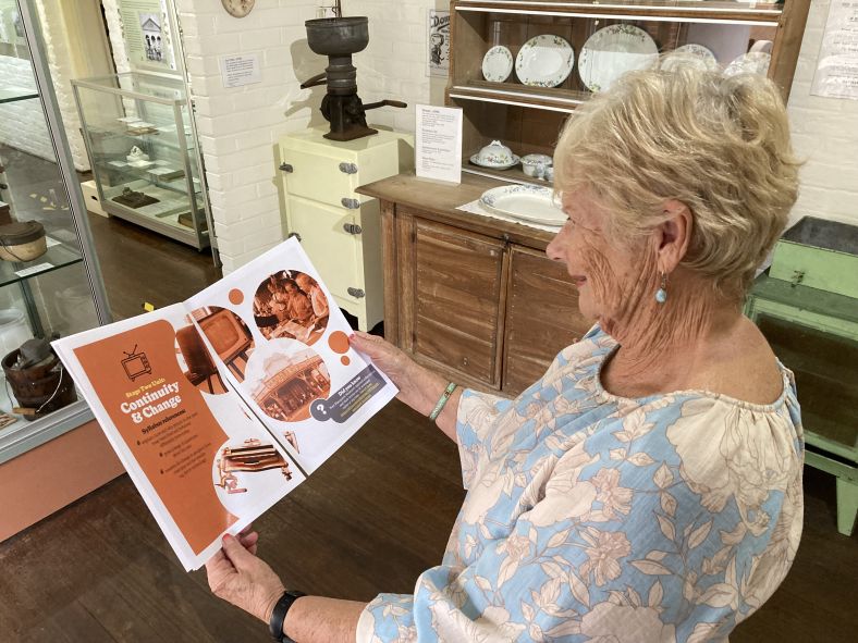 Museum volunteer looking at an educational booklet created for teachers