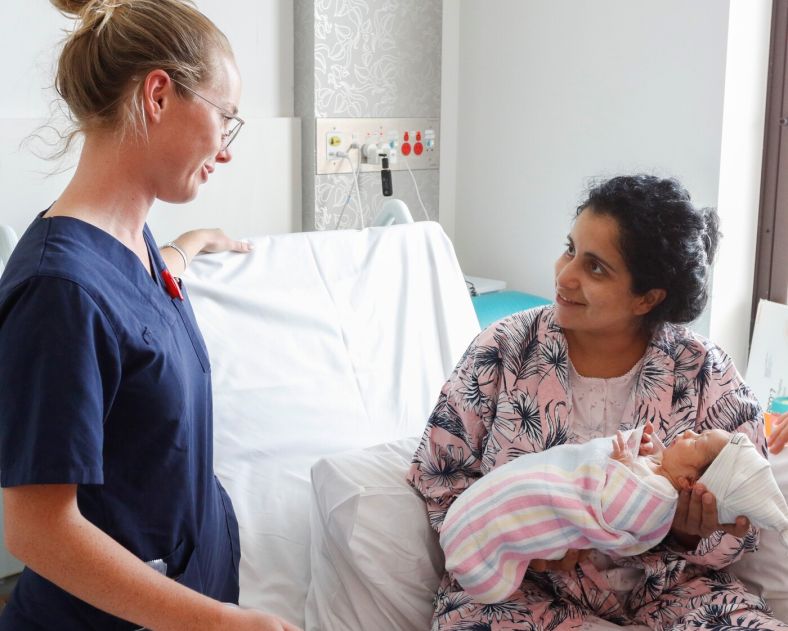 Nurse chatting to mother with baby