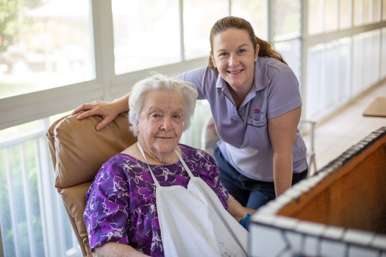 A residential aged-care patient smiles with a staff member at Gilgandra Multipurpose Service