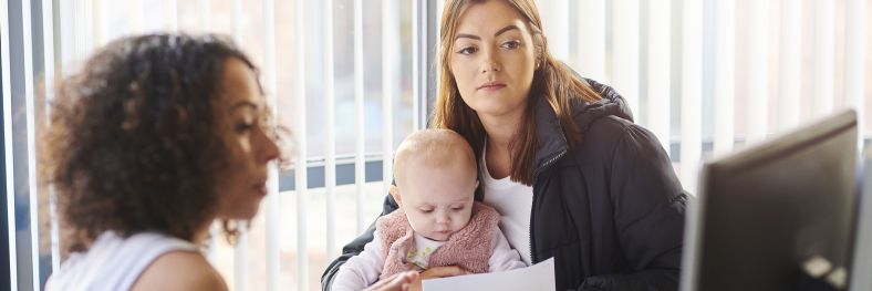 Young mother with support worker looks at options on screen