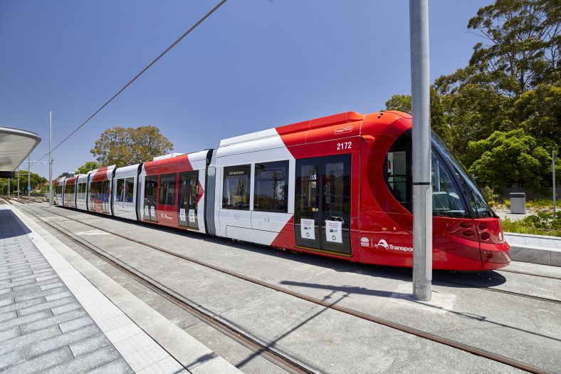 A shot of one of the Parramatta Light Rail Urbos 3 vehicles stationary and gleaming under a sunny blue sky.