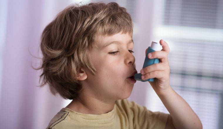 Young boy using an asthma puffer