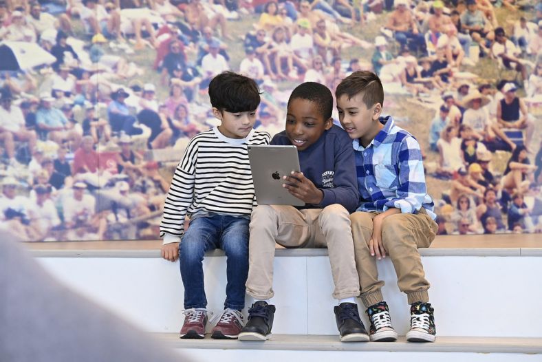 Three children reading an ipad