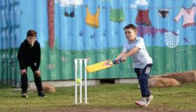 Two children playing cricket