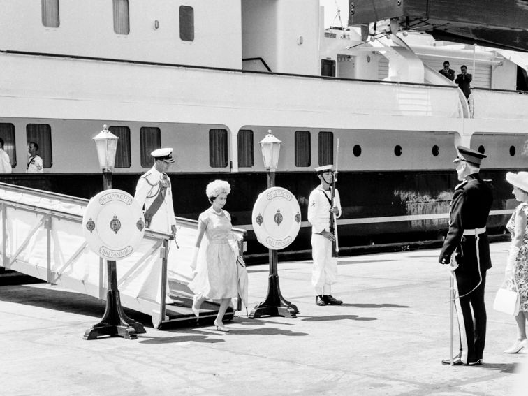 Black and white photo of the Queen and the Duke of Edinburgh disembarking the royal yacht at Sydney Harbour in 1963