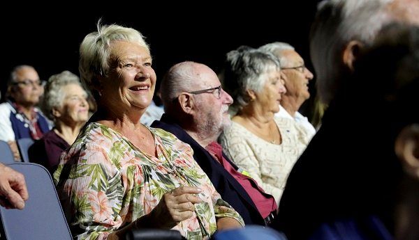 Lady smiling cheerfully in audience at Premiers Gala Concert