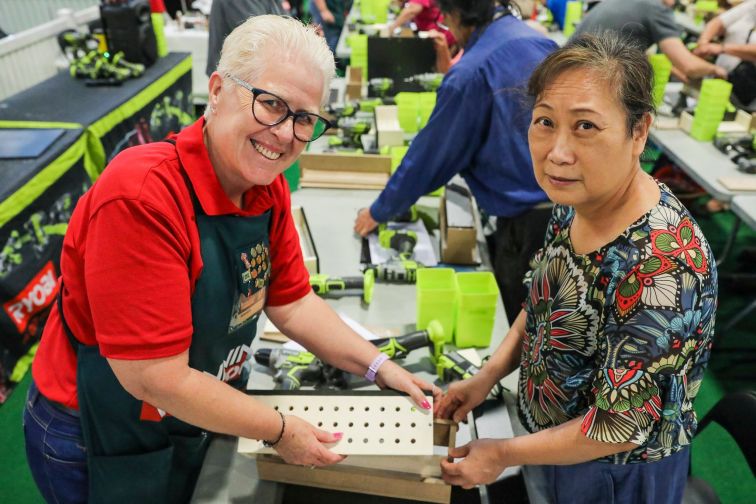 Bunnings rep assists lady with drill