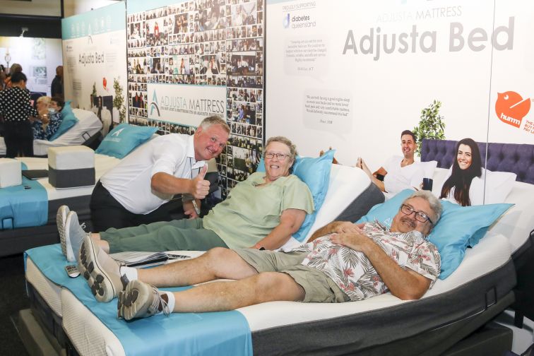 seniors testing mattresses at expo stall 