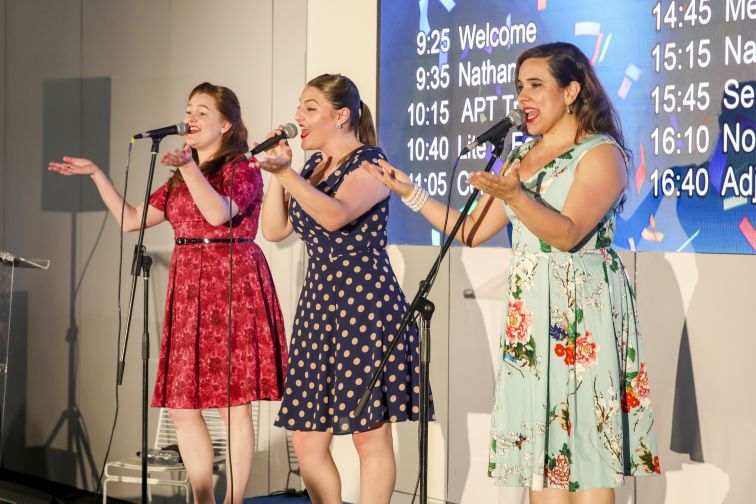 three female performers singing