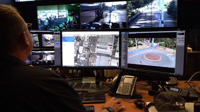 A man observes six screens, showing CCTV footage in Sydney Olympic Park.