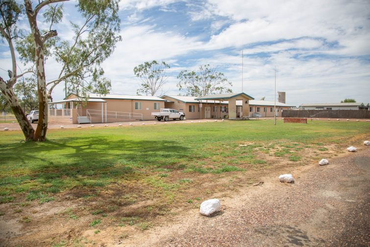 Looking towards the Goodooga Health Service along the driveway entry, grass and trees