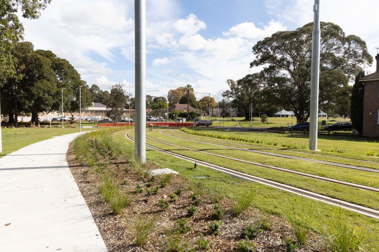 A shot of the Parramatta Light Rail 'Green track' going past Cumberland Hospital Precinct.