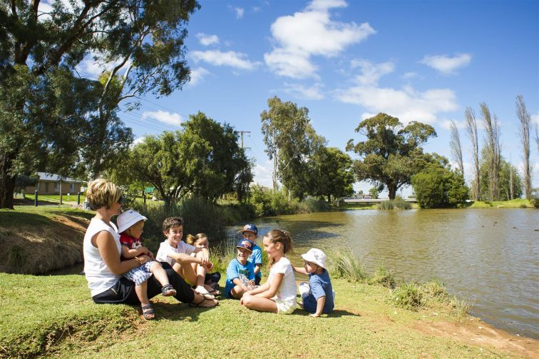 family sitting by the water at Kelly reserve