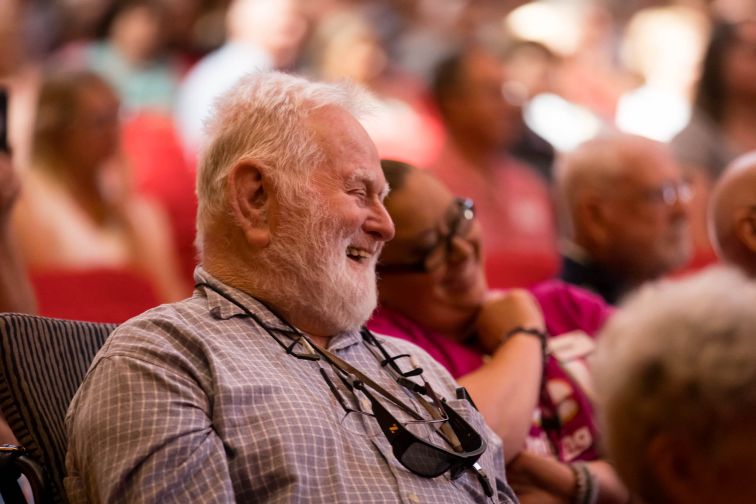 older man laughing in audience