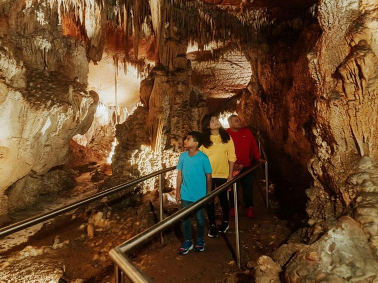 Visitors walk along a path surrounded by beautiful cave formations in Mulwaree Cave. Credit: Remy