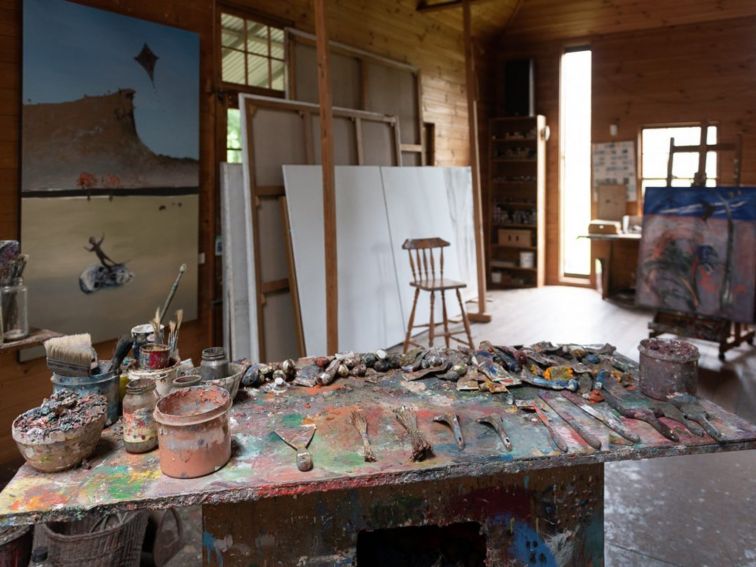 An artist's studio with paint all over a bench