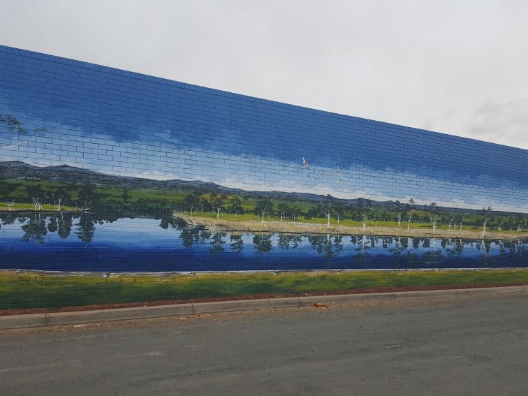 A large mural of the Murray River covers a brick wall in Howlong.