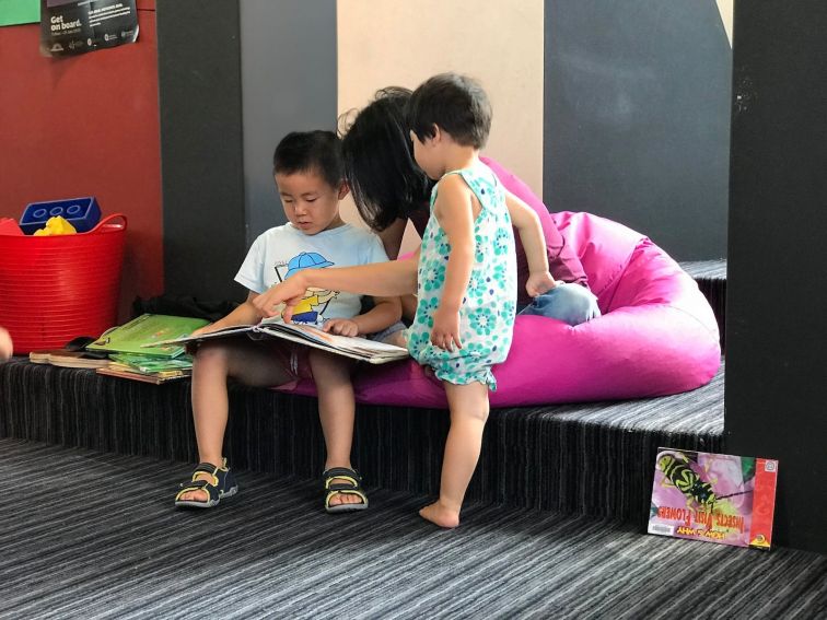 Family enjoying reading a book together at the Library