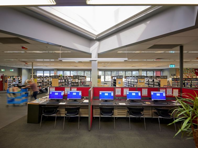 5 computer workstations in a large library setting
