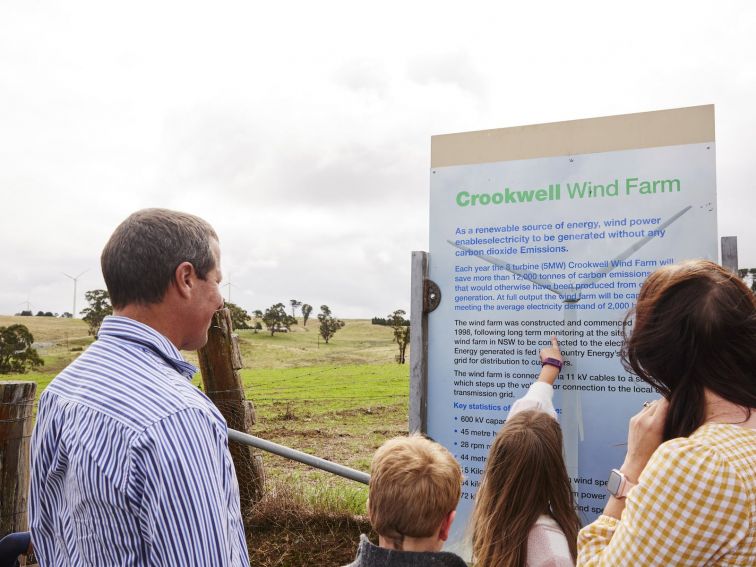 Family reading wind farm signage