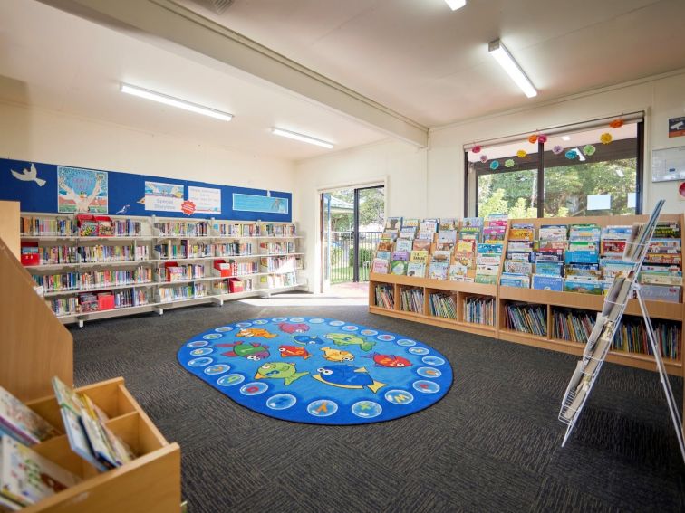 The kids area of the library features colourful rugs and books for children.
