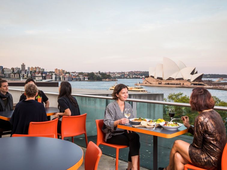 People dining at the MCA Cafe with Sydney Harbour in the background