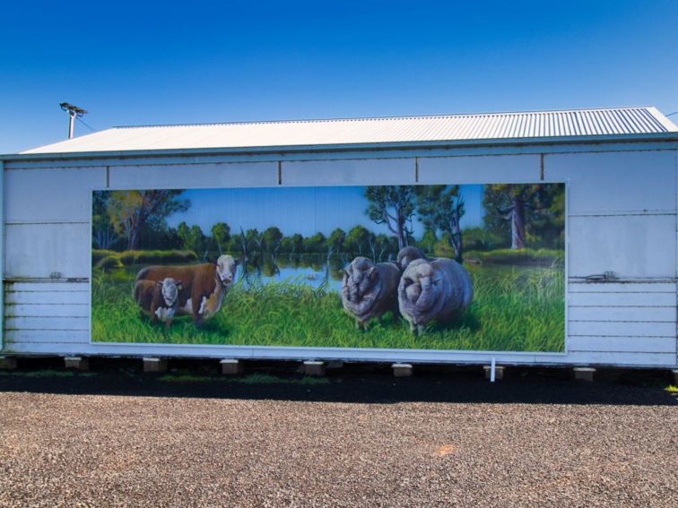 A panel mural featuring two cows and two sheep in green pasture.