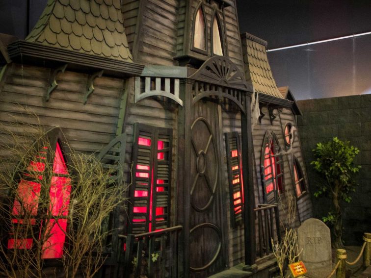 Wooden haunted house with red lit windows