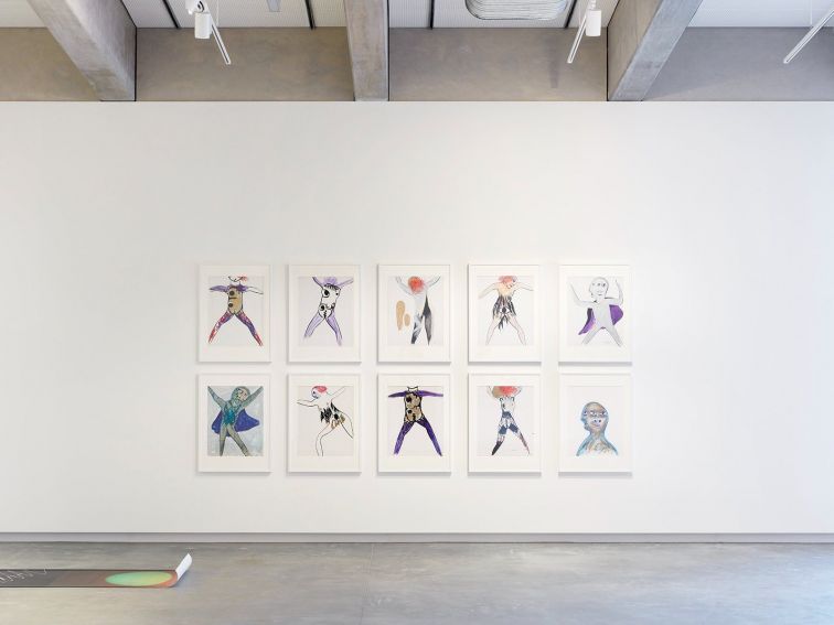 10 abstract drawings hanging on a white gallery wall