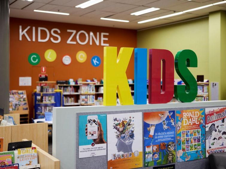 Children's books and play area with colourful signage.