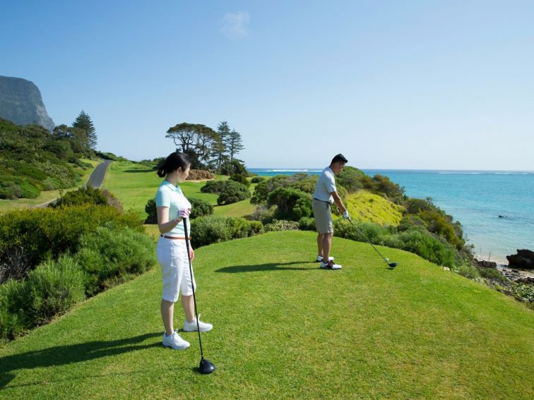 Couple enjoying a round of golf at Lord Howe Island Golf Course with ocean views