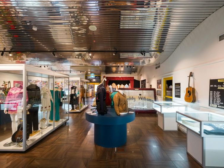 Depicts a landscape photograph of inside the Australian Country Music Hall of Fame exhibition