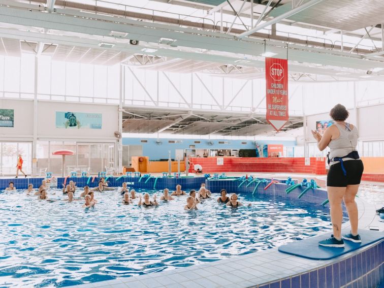 a group of elderly swimmers enjoying an aerobics lesson in the pool