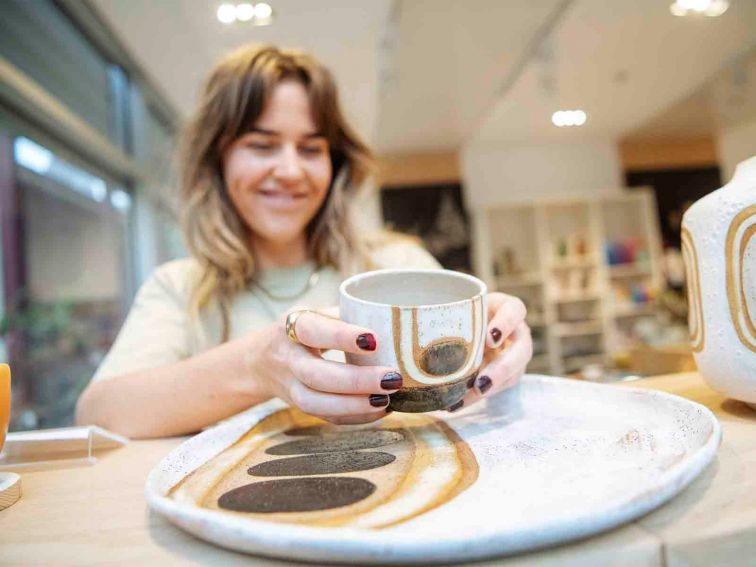Woman picks up ceramic cup in store