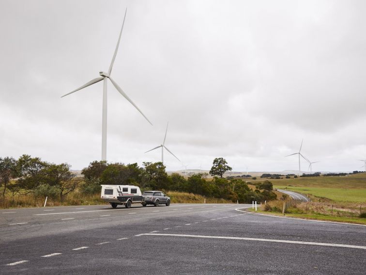 Crookwell Wind Farm with caravan and car driving through foreground