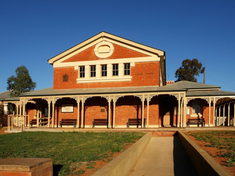 Two storey redbrick building with arched verandah